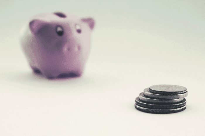 pink piggy bank with stack of coins