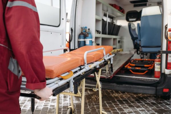 empt stretcher being loaded onto ambulance by EMT