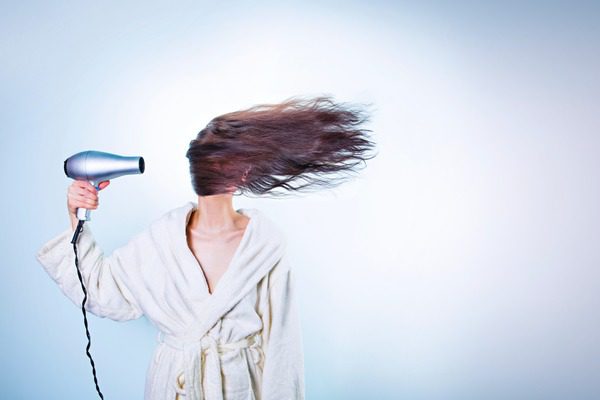woman blow drying hairto the left in humorous fashion